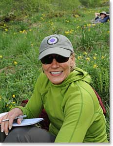 Carol sitting in the meadow catching up on  her journal entries