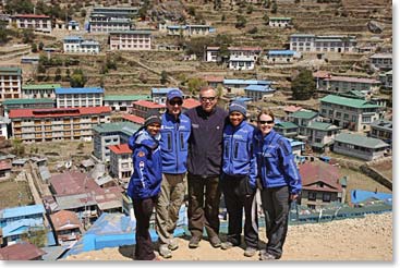 The team stands above the colorful rooftops of Namche