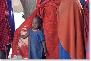 Young child peeking through her mother’s safety