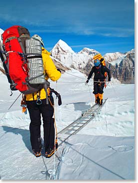 Steve holds the rope taut for Daniel on a ladder crossing as the team moves between Camp I and II.