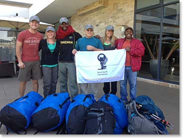 Team holding the “Spinal Health International’s Klimb 4 Kidz” banner