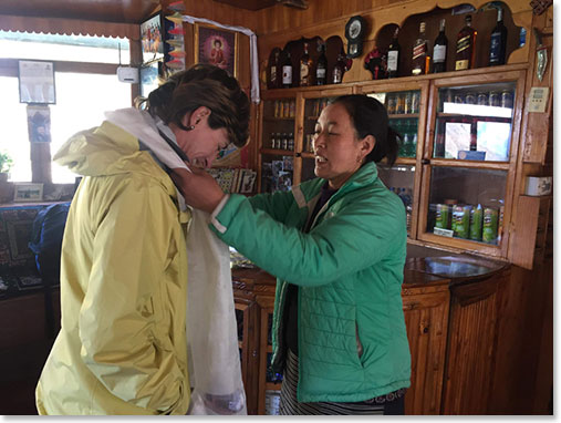Yangzee presenting Adriana with a Khata blessing scarf before she starts her trek down.